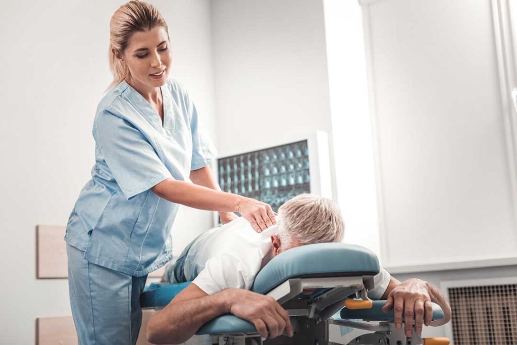 Adult receiving a spinal adjustment in a bright clinical room while discussing wellness habits with a practitioner